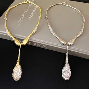 Gros plan d'un collier avec pendentif goutte en métal irrégulier et strass