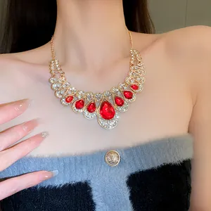 Stunning detail of a gold statement necklace featuring large red teardrop stones