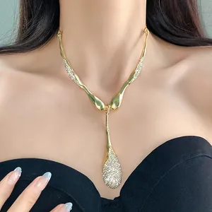 Gros plan d'un collier goutte irrégulier en or de luxe avec des détails en strass