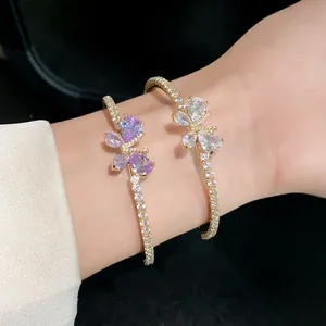 Détail montrant le design papillon en zircon sur un bracelet jonc luxueux plaqué or