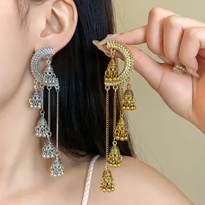 Close-up of vintage court style long tassel earrings with ornate bell pendants