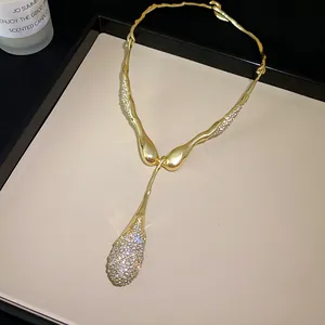 Gros plan d'un collier pendentif goutte d'eau en métal irrégulier avec strass brillants
