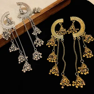Detailed view of ornate gold and silver Jhumka earrings with long tassels.