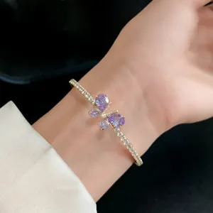 Vue détaillée d'un élégant bracelet papillon en zircon doré porté sur le poignet