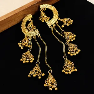 Detailed close-up of intricate gold jhumka bells on elegant long tassel drop earrings