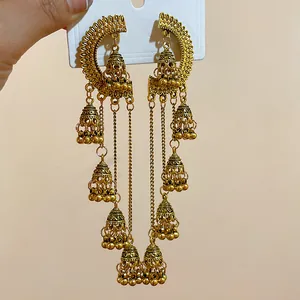Detailed view of vintage gold jhumka style long tassel earrings with intricate engraving.