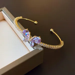Gros plan d'un élégant bracelet jonc papillon en zircon violet sur un coffret à bijoux