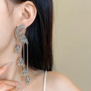 Detail view of vintage long tassel earrings with Jhumka bells on a model.