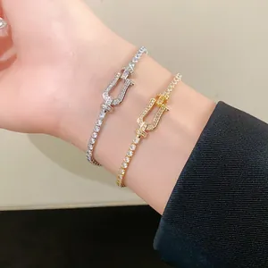 Detailed view of gold and silver horseshoe buckle bracelets featuring paved zircon stones