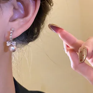 Elegant silver bow pearl drop earrings for women featuring sparkling crystal details