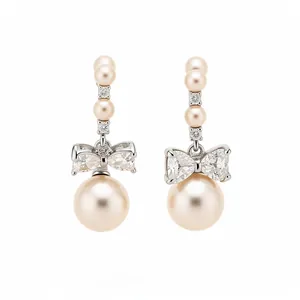 Elegant silver bowknot drop earrings featuring lustrous cream pearls and crystals