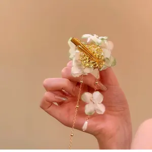 Elegant fabric flower hair clip with delicate pearl tassels for a fresh and sweet holiday look.