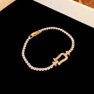 Close-up of elegant gold tennis bracelet with shimmering zircon horseshoe clasp