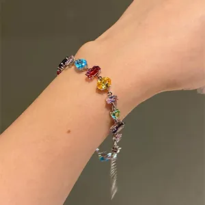 Close-up detail of a vibrant multi-shape cubic zirconia bracelet worn on a female wrist