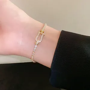 Detail shot of a gold horseshoe buckle bracelet paved with sparkling cubic zirconia
