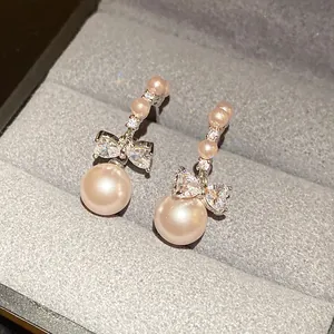 Elegant pink pearl drop earrings with a sparkling crystal bowknot design detail for women