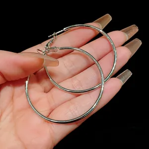 Detailed view of large silver metal hoop earrings with a minimalist circular design