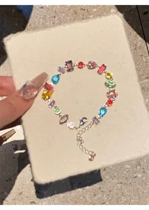Macro view of a dainty colorful zircon bracelet featuring mixed gemstone shapes