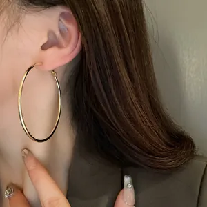 Elegant large round gold hoop earrings for women shown on model close-up detail view