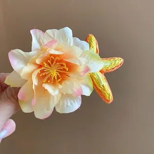 Gros plan montrant les pétales de fleurs et l'étoile en raphia tissé d'une barrette chic
