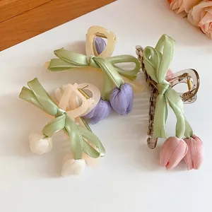 Elegant fabric tulip bow hair claws in various pastel colors on a clean white surface