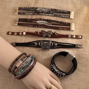 Bohemian leather bracelet collection with butterfly and feather charms on linen background
