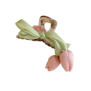 Elegant tulip floral hair claw clip featuring green ribbon bow and pink fabric petals