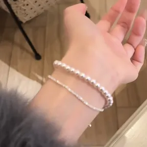 Vista dettagliata di un elegante bracciale in zirconi e perle in stile francese al polso