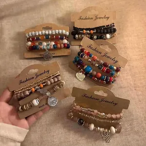 Detail of multiple beaded bracelet sets on kraft cards with metal charms and wooden beads