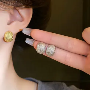 Irregular bean-shaped earrings with a textured glitter finish and silver needles
