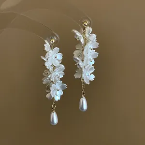 Exquisite detail of white flower cluster dangle earrings featuring elegant teardrop pearls