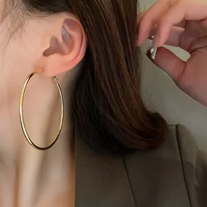 Detailed view of large gold minimalist hoop earring on model for elegant style