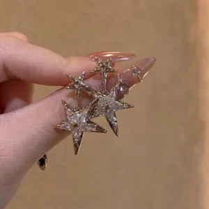 Detailed close-up view of silver star stud earrings featuring sparkling zircon stone inlays