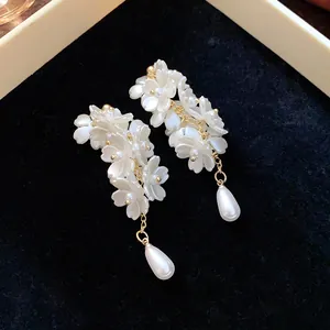 Elegant white flower earrings with teardrop pearls and 18K gold plated details