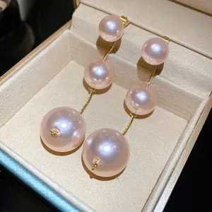 Close-up view of elegant pink pearl drop earrings in a luxury jewelry box.