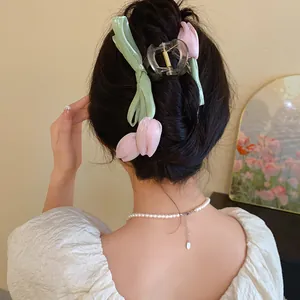 Elegant macro view of a pink fabric tulip hair claw clip styled on a model's dark hair