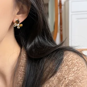 Elegant butterfly stud earrings featuring faux tiger eye stones and sparkling zircon accents