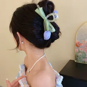 Detail shot of a sweet tulip and mesh bow hair claw clip styled on a woman's hair bun