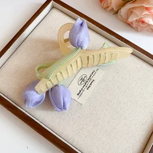 Detailed close-up showing the purple fabric tulip and cream acrylic hair claw clip design
