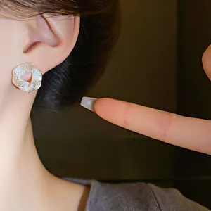 Macro detail of minimalist irregular textured silver stud earrings worn on an earlobe