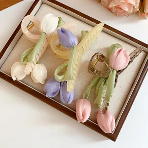 Detailed view of three tulip hair claw clips in pastel colors on a soft display tray