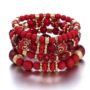 Detailed view of multi-layer red beaded bracelet with gold accents and crystal beads.