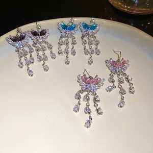 Orecchini a farfalla scintillanti con nappe di zirconi nei colori rosa, blu e viola.