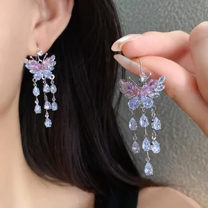 Dettaglio ravvicinato degli orecchini a farfalla in zircone con eleganti gocce d'acqua