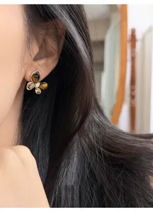 Detailed view of elegant butterfly-shaped earrings with tiger eye stones and zircon