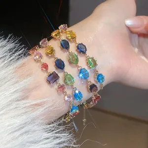 Detailed view of sparkling colorful zircon geometric bracelets worn on a model's wrist