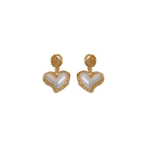 Vintage Baroque style gold heart earrings with white pearl centers and textured metal edges