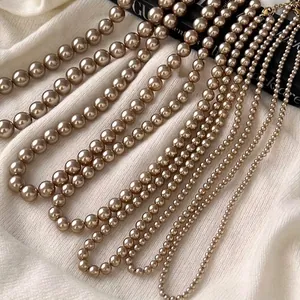 Vintage champagne pearl necklace set with five bead sizes on elegant white knit fabric