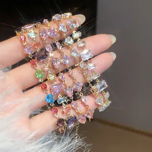 Detailed close-up of multiple colorful zircon bracelets with heart and geometric charms