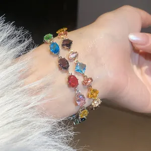 Close-up view of two colorful geometric cubic zirconia bracelets on a female wrist